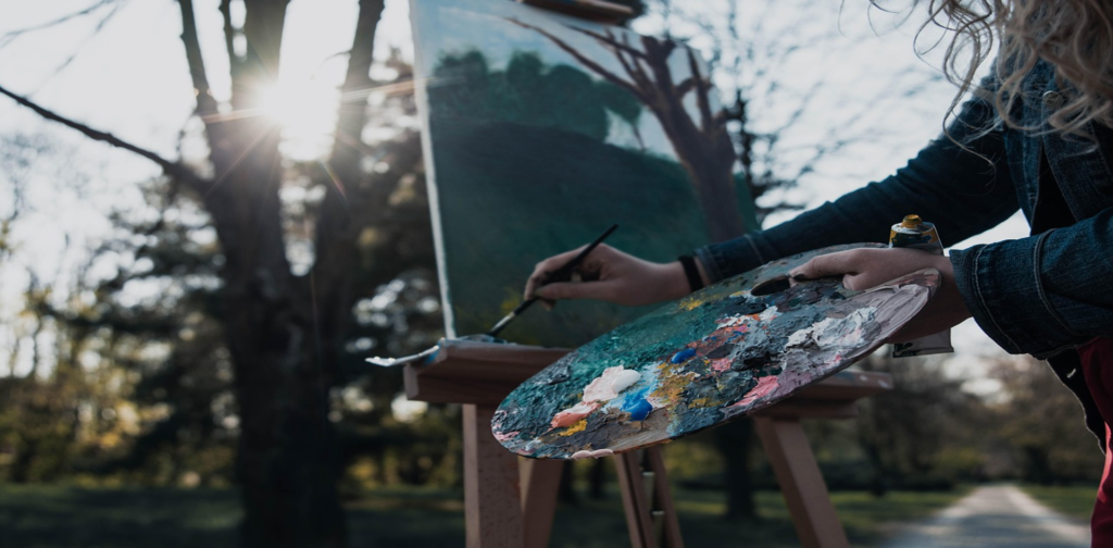 Une jeune artiste qui peint à l'extérieur.