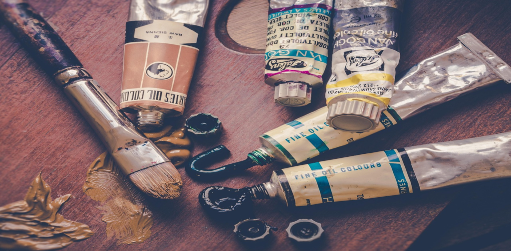 Plusieurs tubes de peinture à l'huile avec un pinceau.